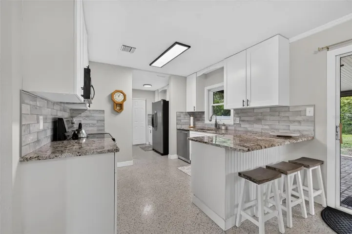 Renovated Kitchen with white shaker cabinets, granite counters and subway tile backsplash
