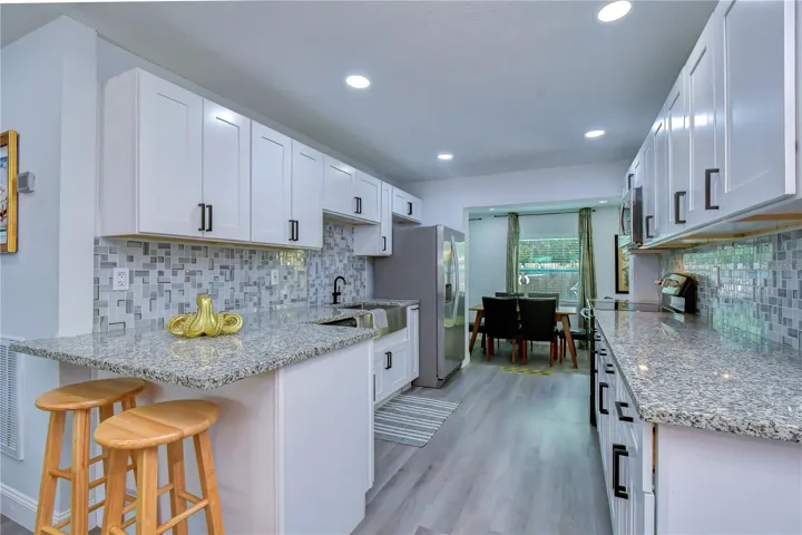 updated kitchen with granite counters and stainless steel appliances