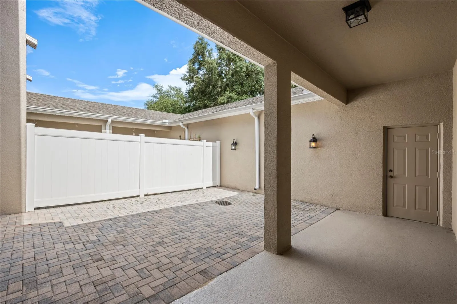 Paver patio with covered walkway from garage
