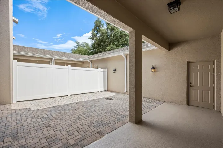 Paver patio with covered walkway from garage