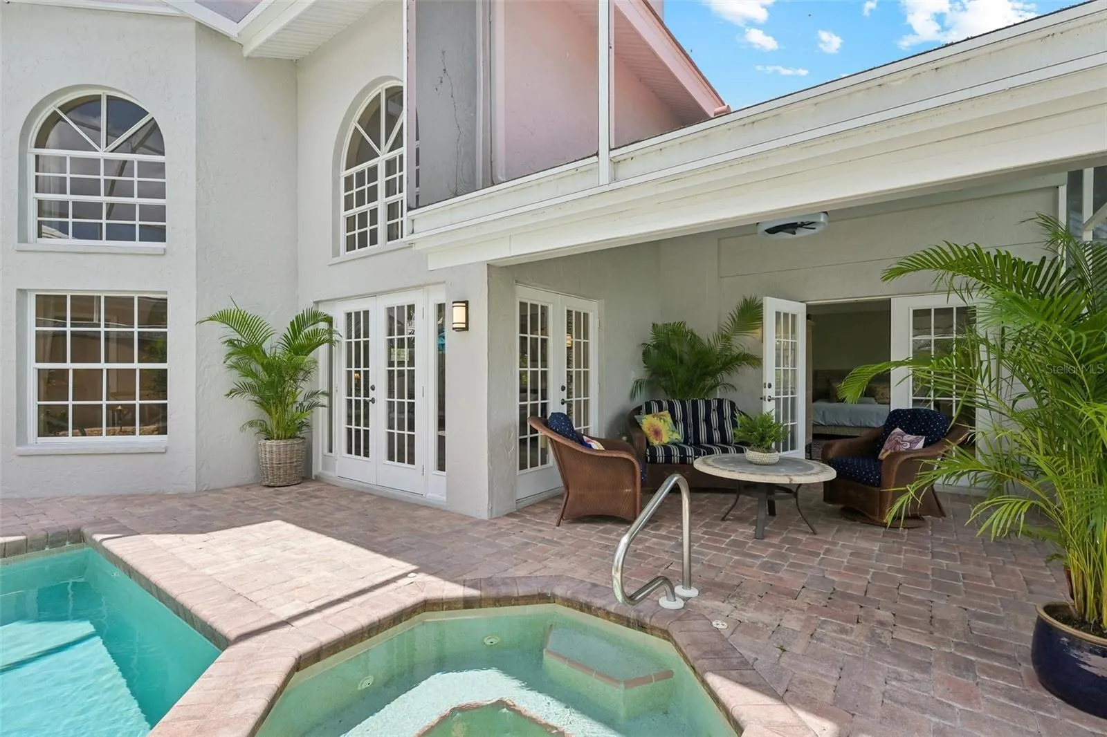 Watch the sunset from the covered seating area with french doors to the primary suite.