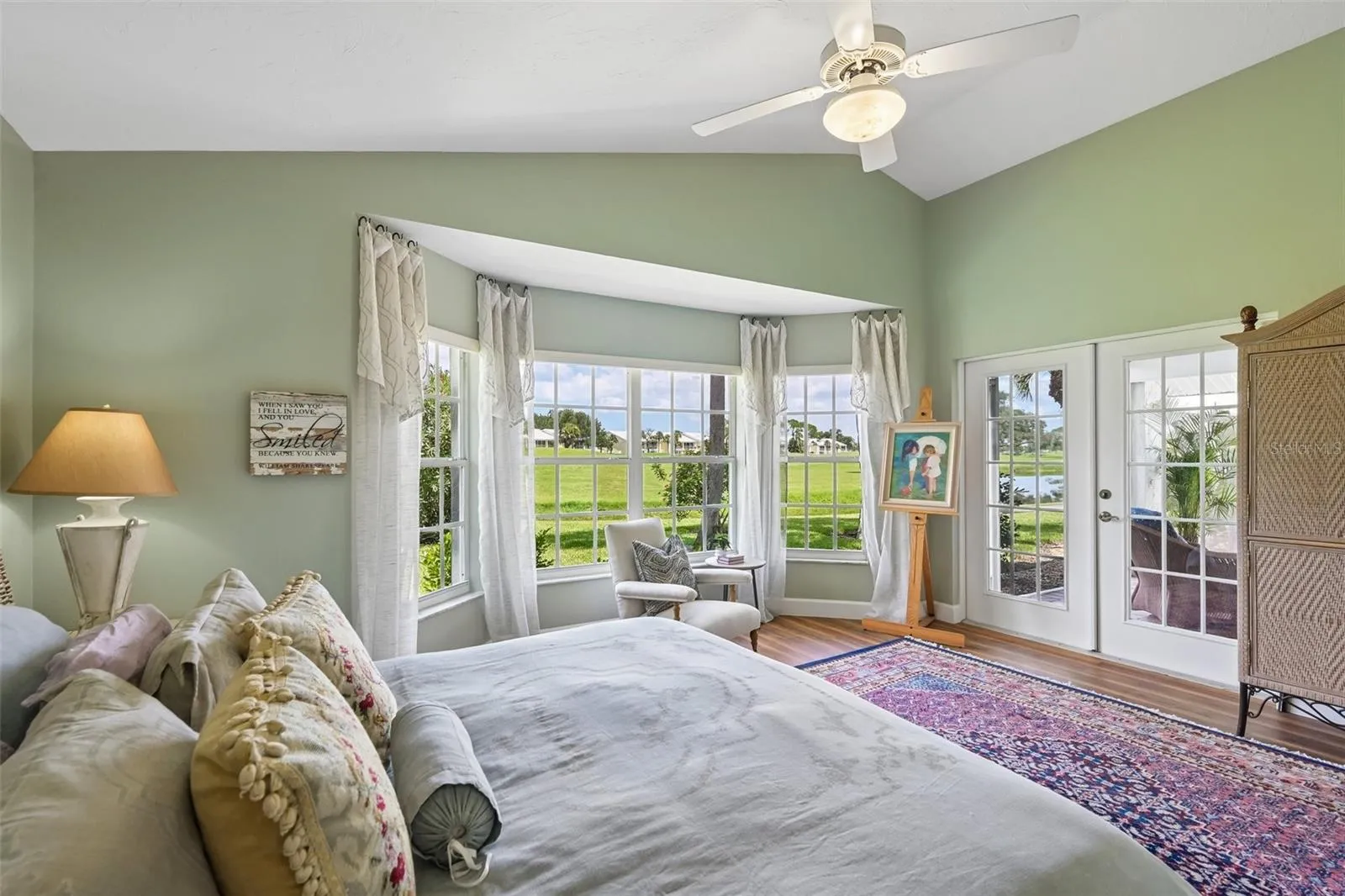 Primary suite overlooking the canal and golf course, with french door access to the lanai and pool area.