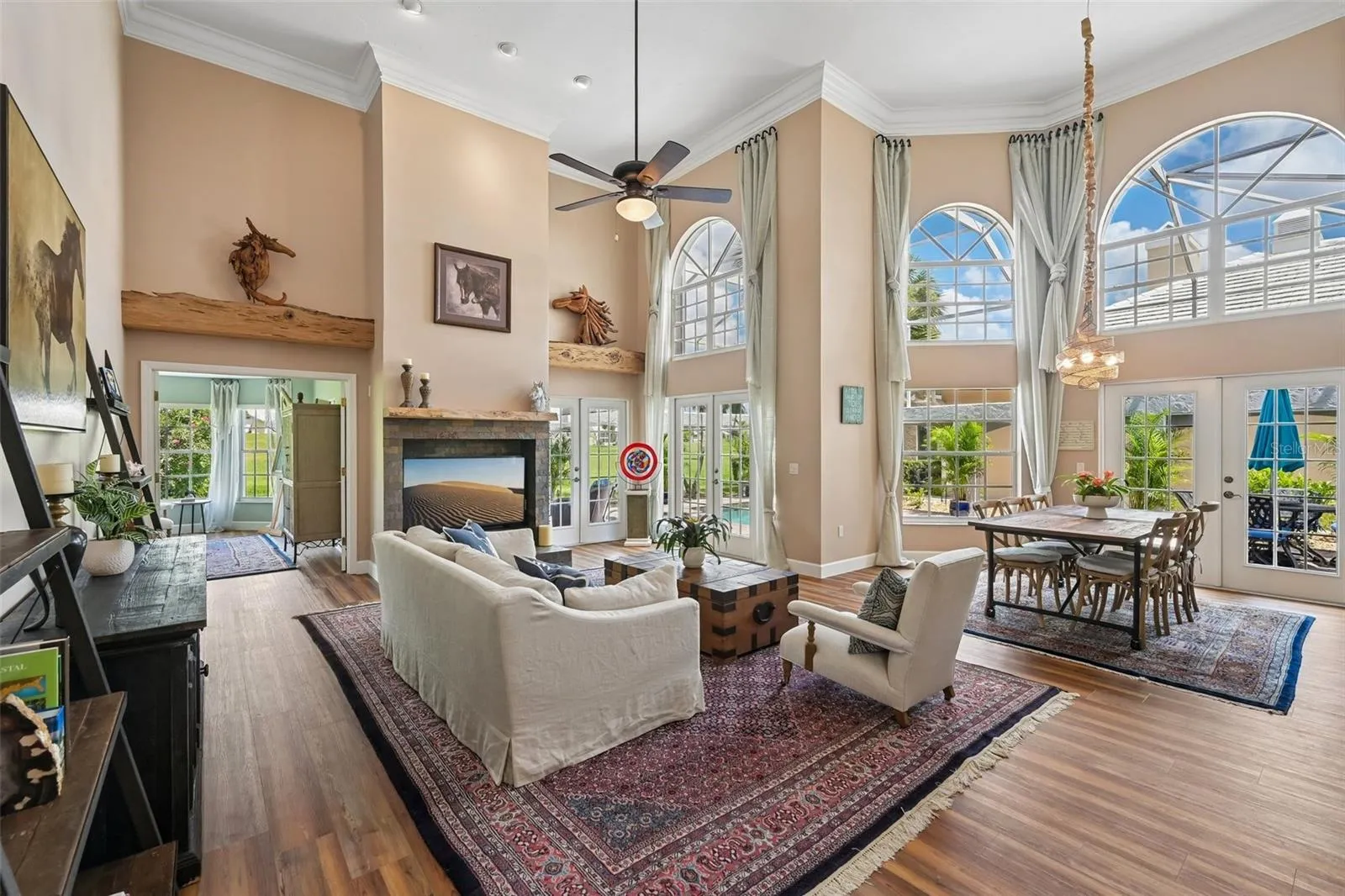16 foot cathedral ceilings with floor to ceiling windows and french doors frame the view to the pool, canal and golf course beyond.