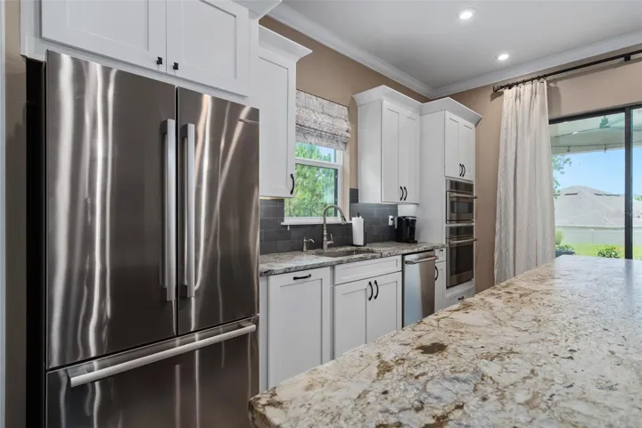 Upgraded solid wood cabinetry with oversized crown molding, under cabinet lighting, double under counter trash containers and Leathered Granite Countertops complete the kitchen.
