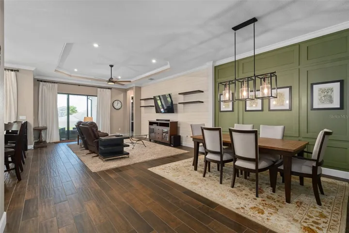 Dining and Family Room with a view of the Lanai. Please notice the Custom Wall Woodwork as well as the Crown Molding
