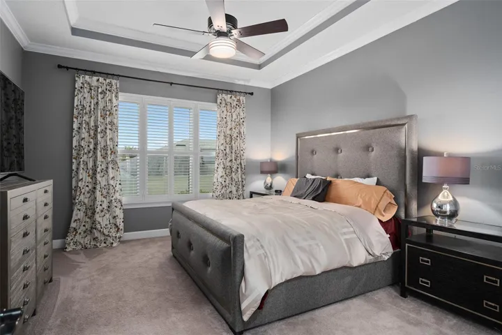 The Generous Size of the Primary Suite also offers a Tray Ceiling in addition to 10' Ceilings, Crown Molding and Plantation Shutters.