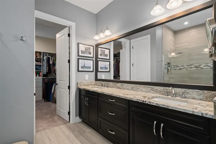 Upgraded Comfort Height Cabinetry with additional drawers, Leathered Granite, Rectangular Under Mount Sinks and a Framed Mirror