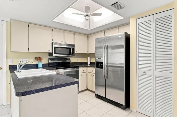 Kitchen with stainless steel appliances & pantry.