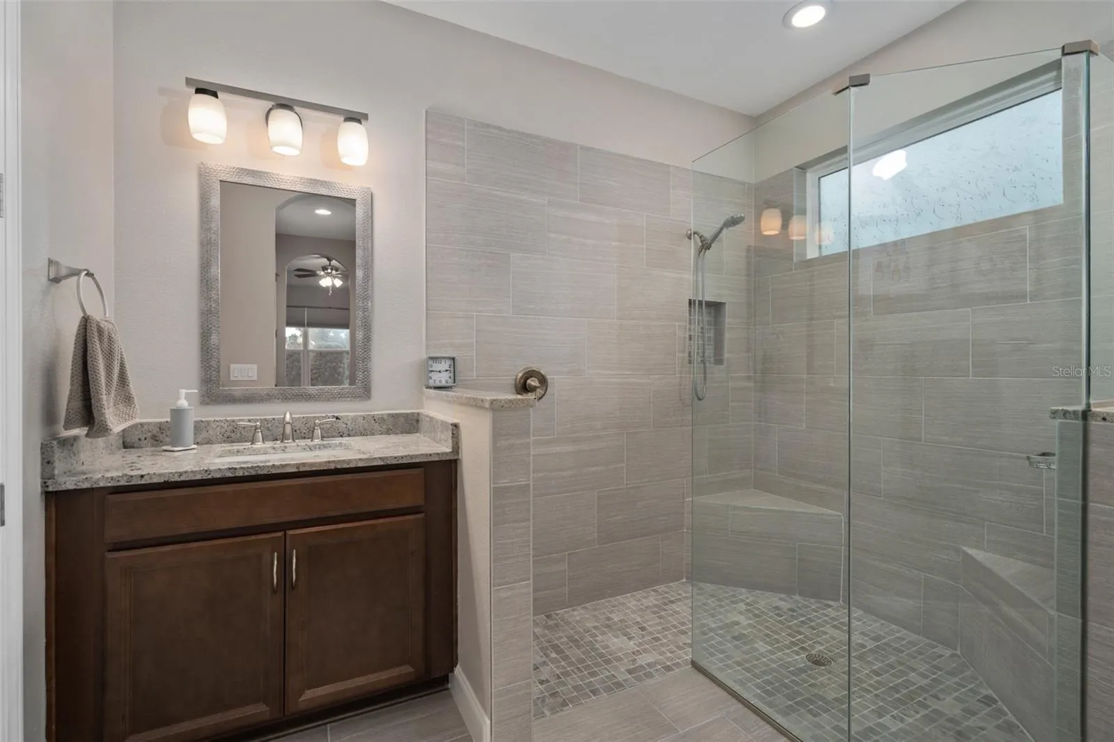 Primary En-Suite Offers a Remodeled Shower with Corner Seats and Split Comfort Height Vanities