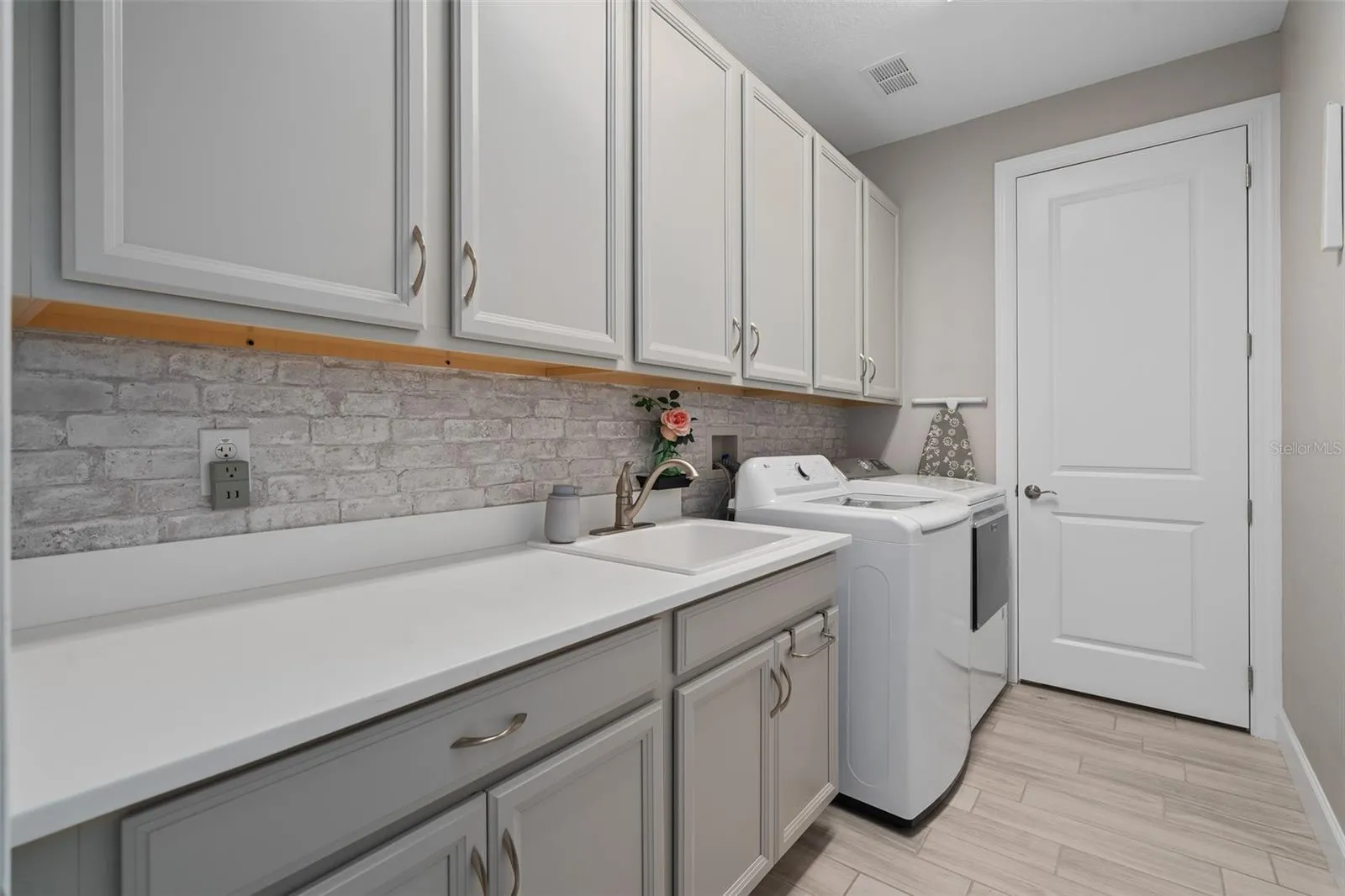 The Laundry Room offers Plenty of Cabinetry and a Sink for your convenience