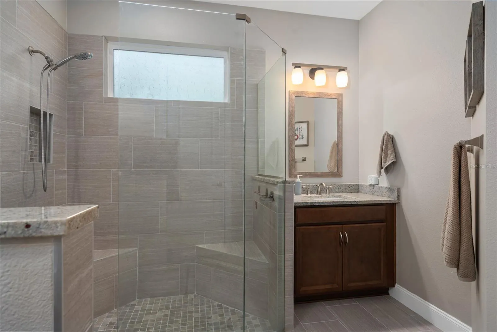 Primary En-Suite Offers a Remodeled Shower with Corner Seats and Split Comfort Height Vanities