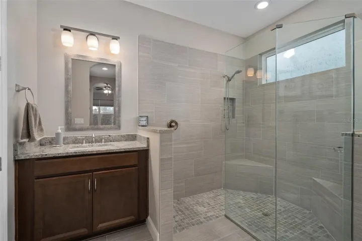 Primary En-Suite Offers a Remodeled Shower with Corner Seats and Split Comfort Height Vanities