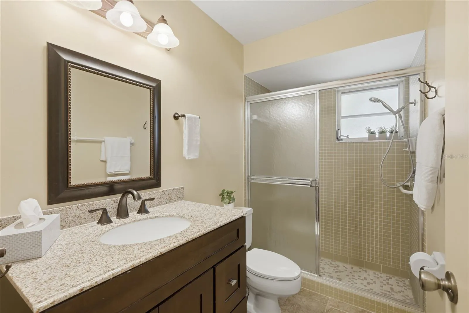 Second bathroom with a walk-in shower and natural light.