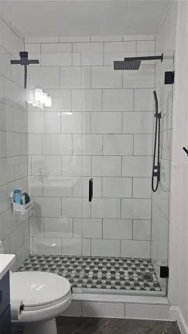 Porcelain shower with shower door guest bathroom
