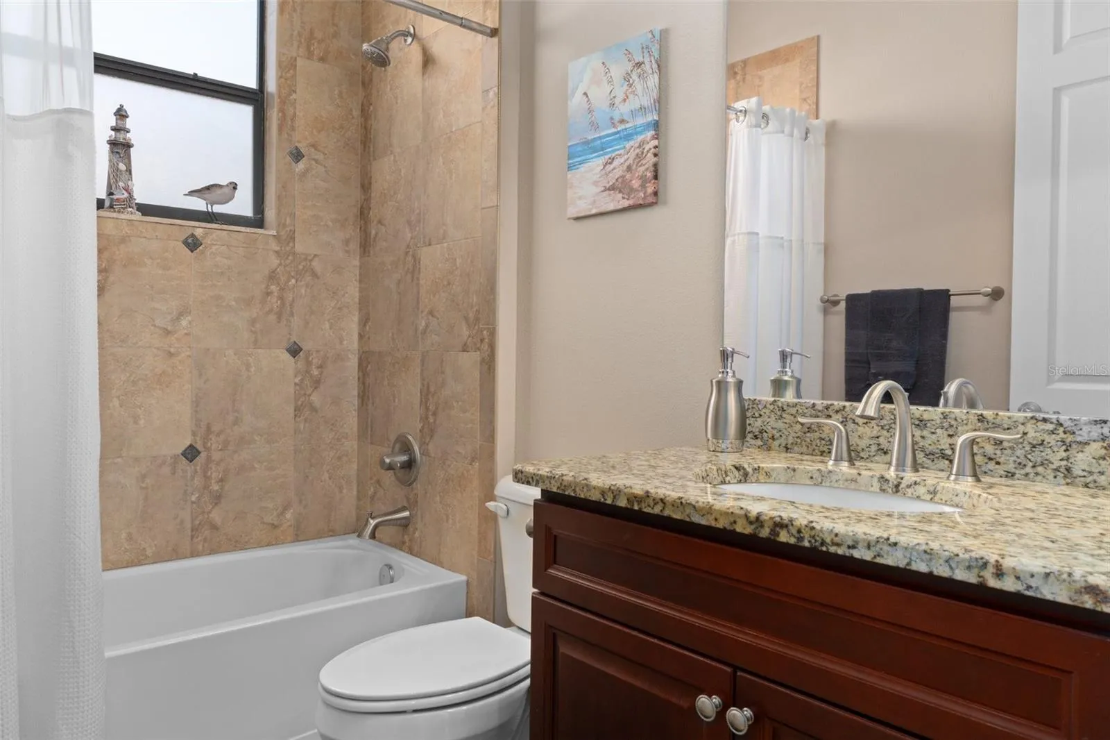 Guest Bathroom decor ties in with the rest of the home and features comfort height vanity with a granite top.