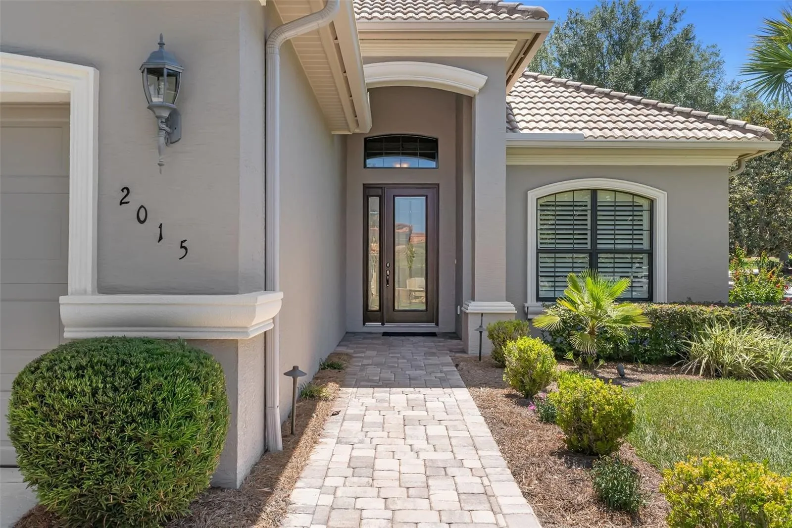 Such a welcoming entry with pavered sidewalk and covered entry.
