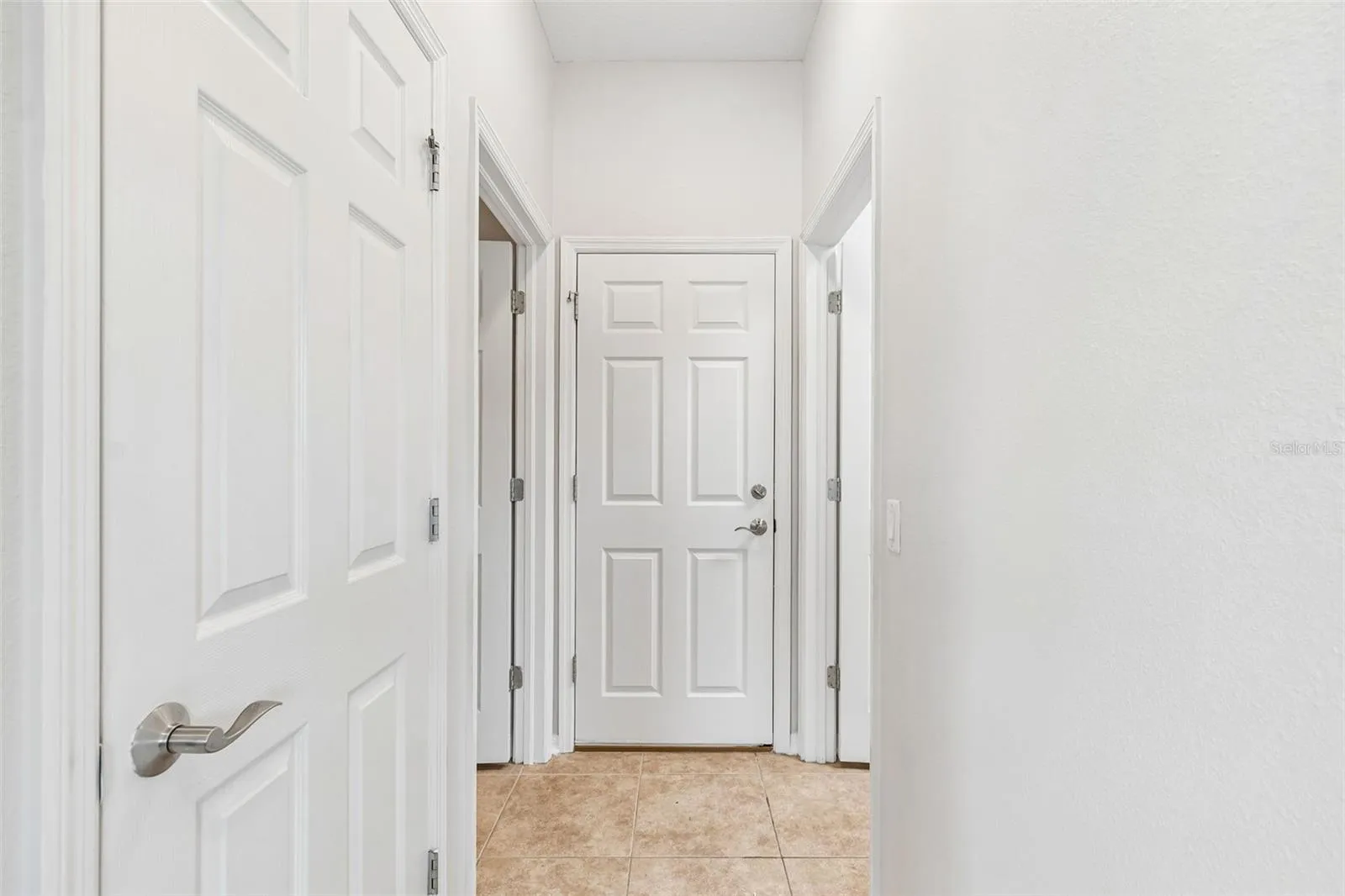 hallway leading to half bath/laundry room/garage