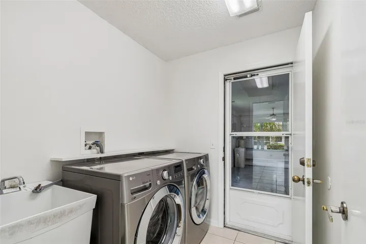 Laundry Room w/ utility sink, door to garage w/ added storm door