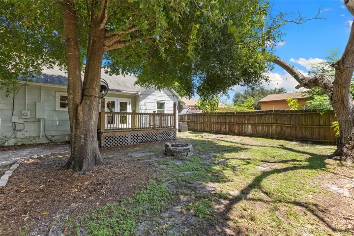 The home's rear elevation with an inviting deck, new privacy fencing, and a shaded, pet-friendly yard.