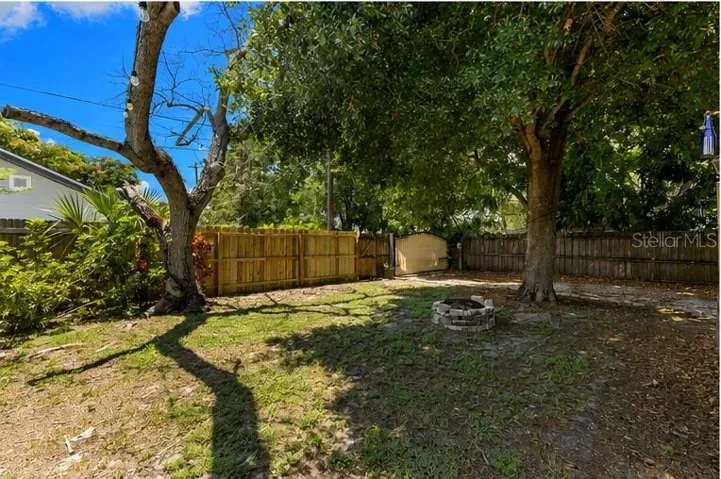 Freshly built privacy fence and gated access frame this spacious backyard retreat, anchored by grand oak shade.