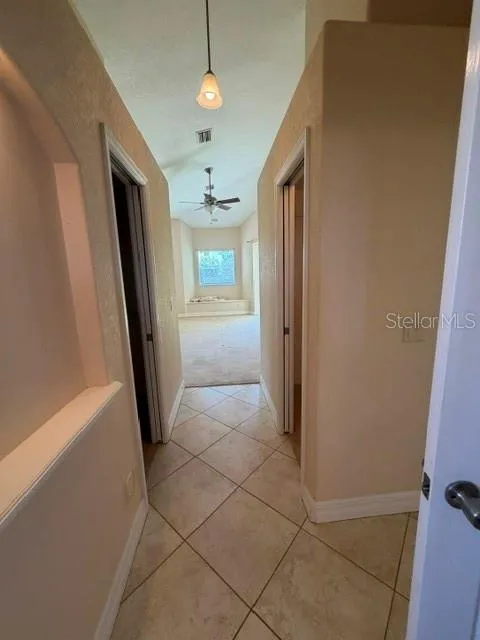Hallway to Primary Bedroom with Walk In Closets on Each Side