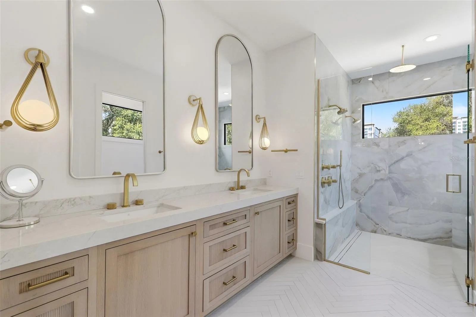 Primary bathroom with dual sinks, custom cabinets and designer lighting