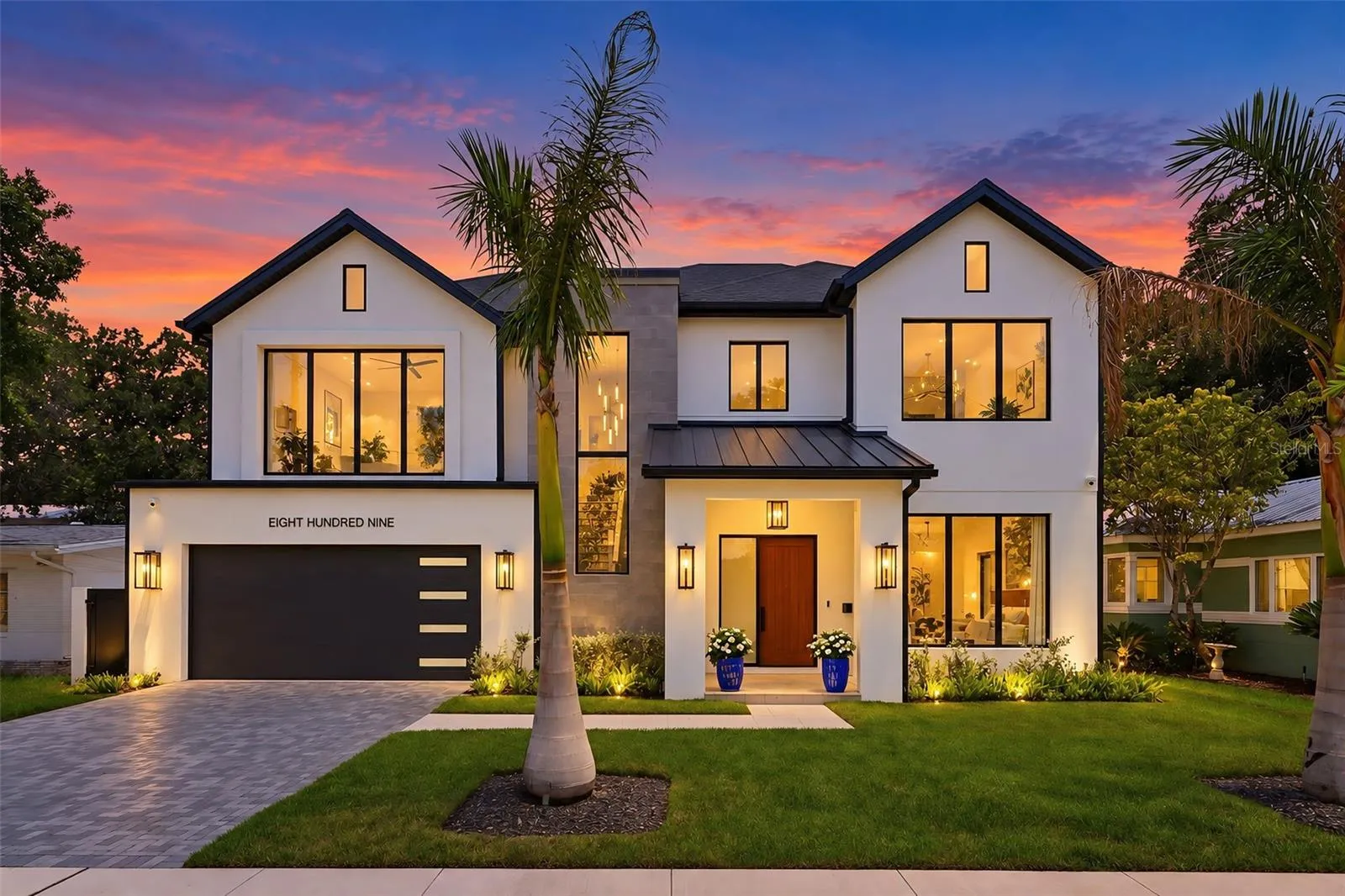 The roof combines architectural shingles with standing-seam metal accents