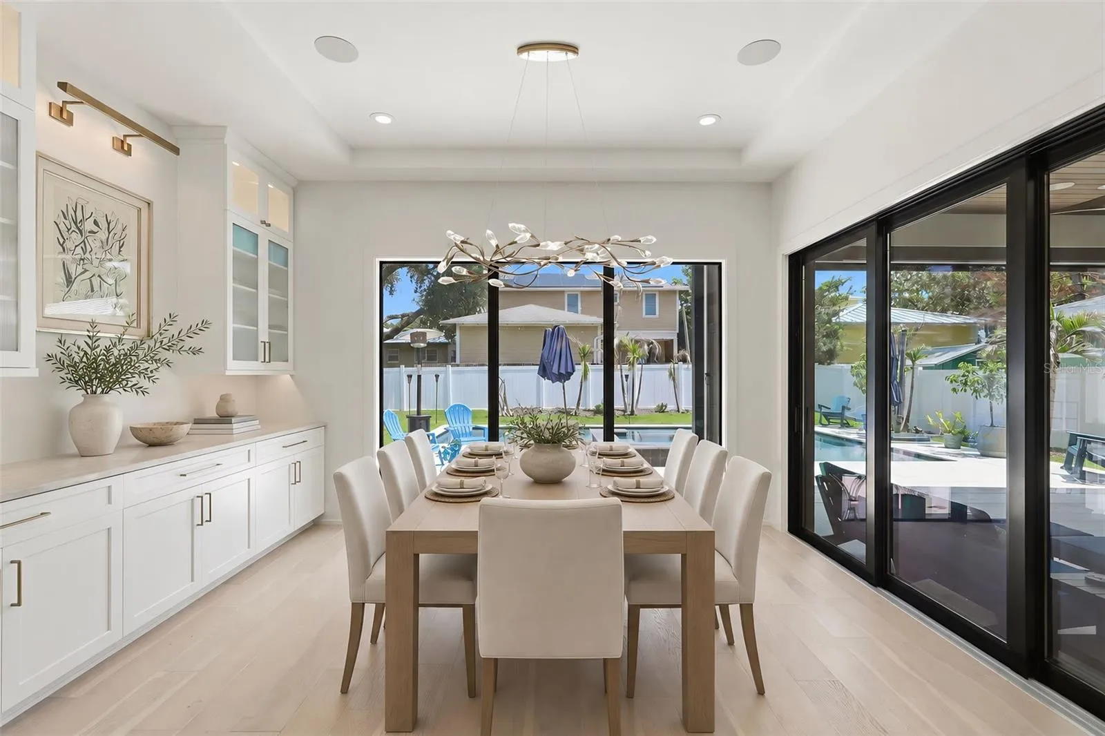 Dining area with custom cabinetry and designer lighting