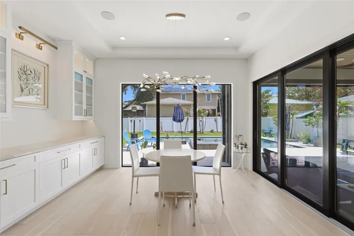 Dining area with custom cabinetry and designer lighting