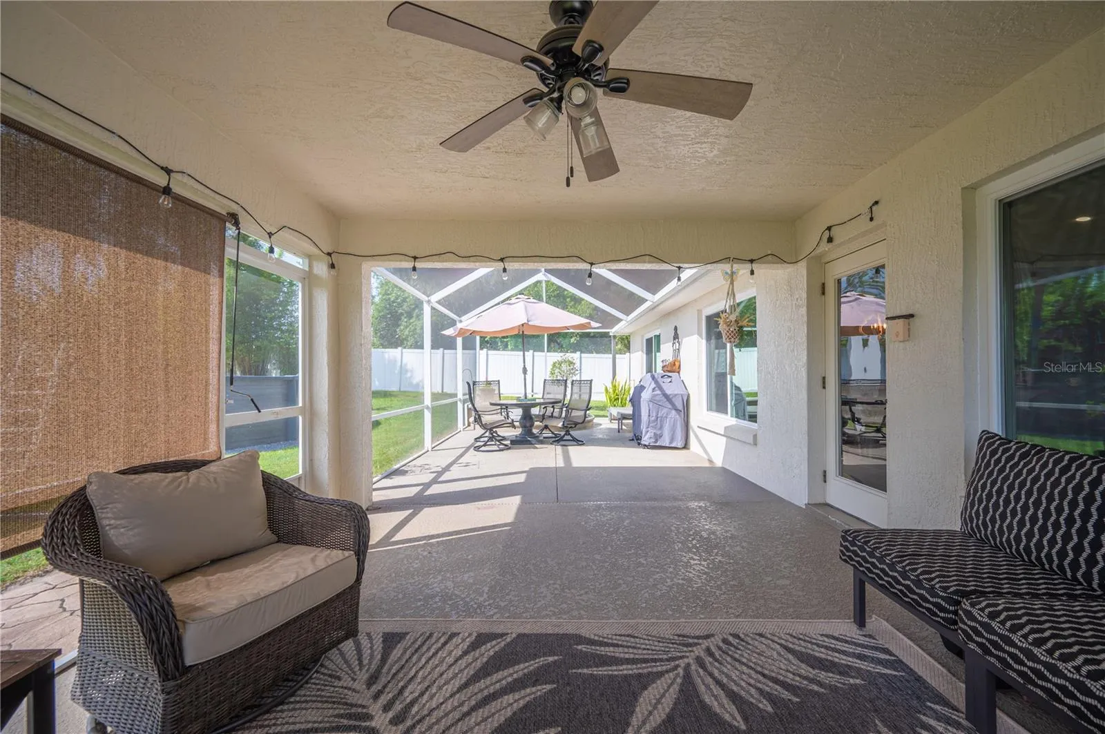 A view from the covered lanai to the screened open portion of the lanai