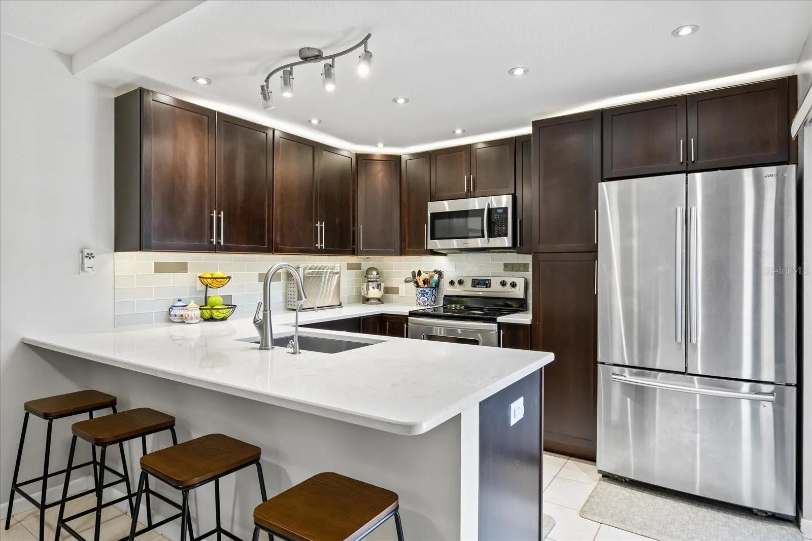 Hardwood cabinetry, abundant storage, and quartz countertops, eat-in space on the breakfast counter, and attractive recessed lighting fit all the checkboxes!