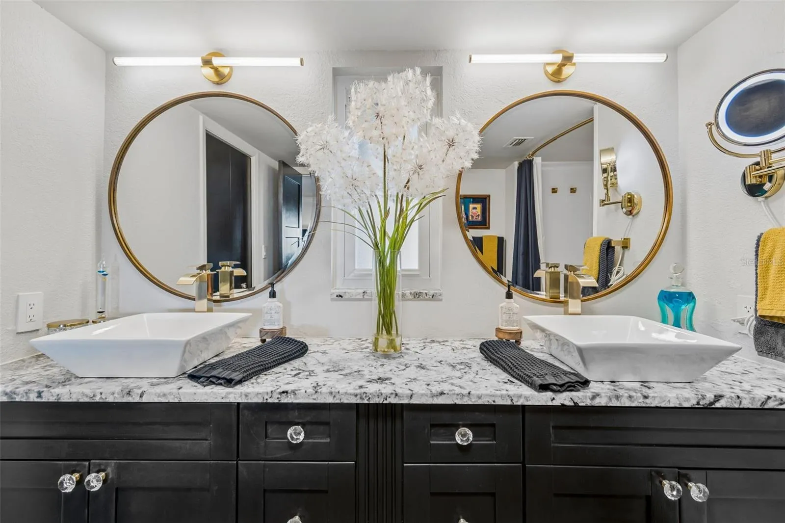 Primary en suite with updated, timeless double vanity, sinks, and mirrors.
