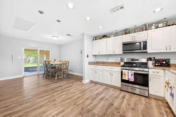 This bright OPEN CONCEPT floor plan offers an easy flow from the kitchen to the living and dining areas where two sets of sliding glass doors access the expansive SCREENED LANAI to make the most of indoor/outdoor living!