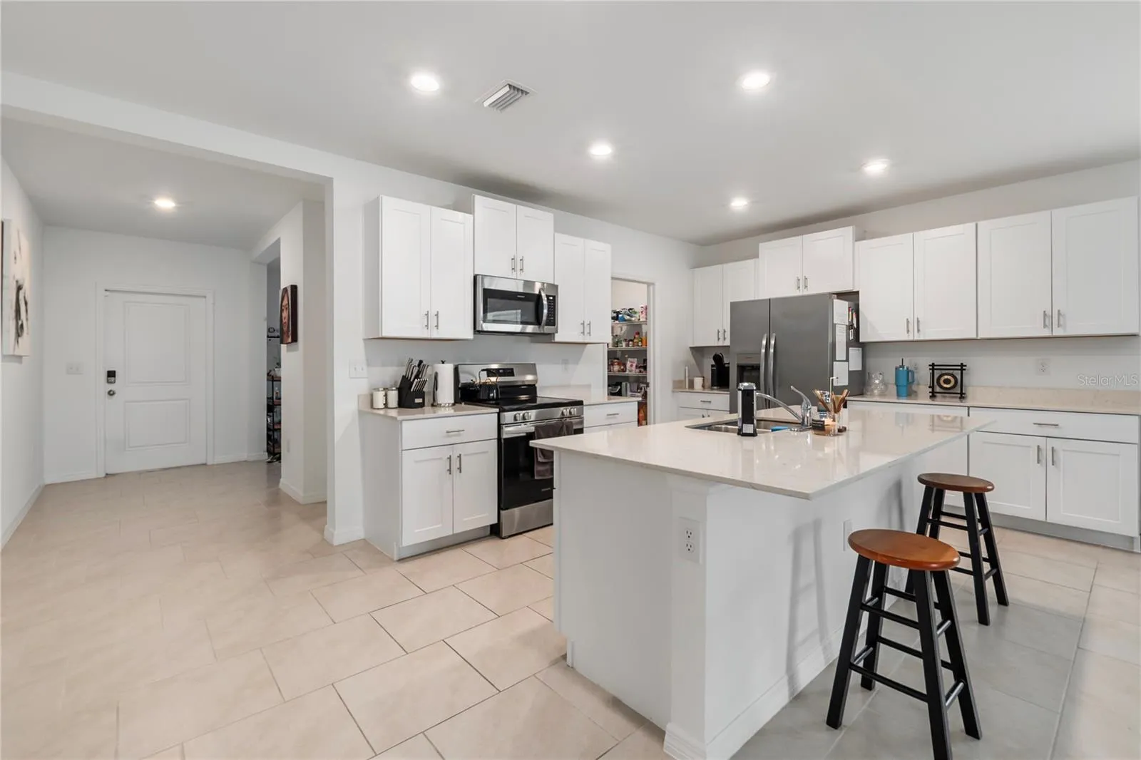 Gourmet kitchen with large center island, abundant cabinetry, and seamless flow into the living and dining areas.