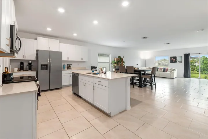 Gourmet kitchen with large center island, abundant cabinetry, and seamless flow into the living and dining areas.