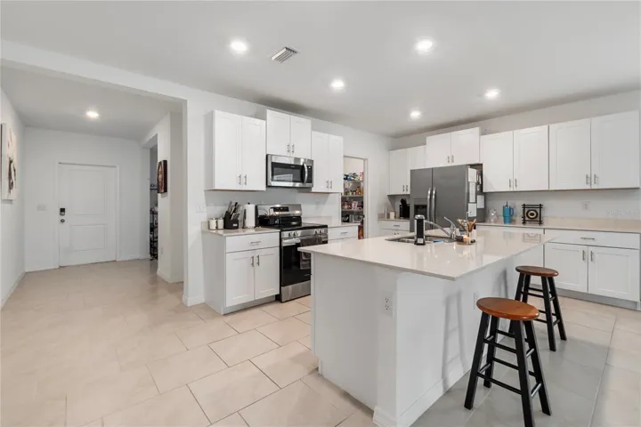 Gourmet kitchen with large center island, abundant cabinetry, and seamless flow into the living and dining areas.