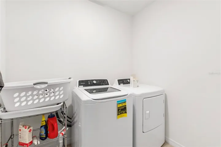 Dedicated laundry room with additional storage space for everyday convenience.