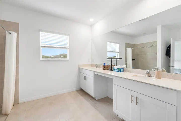Luxurious primary bathroom with dual vanities, walk-in shower, and modern finishes.