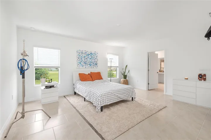 Spacious primary suite with oversized windows, natural light, and room for a king-sized bedroom