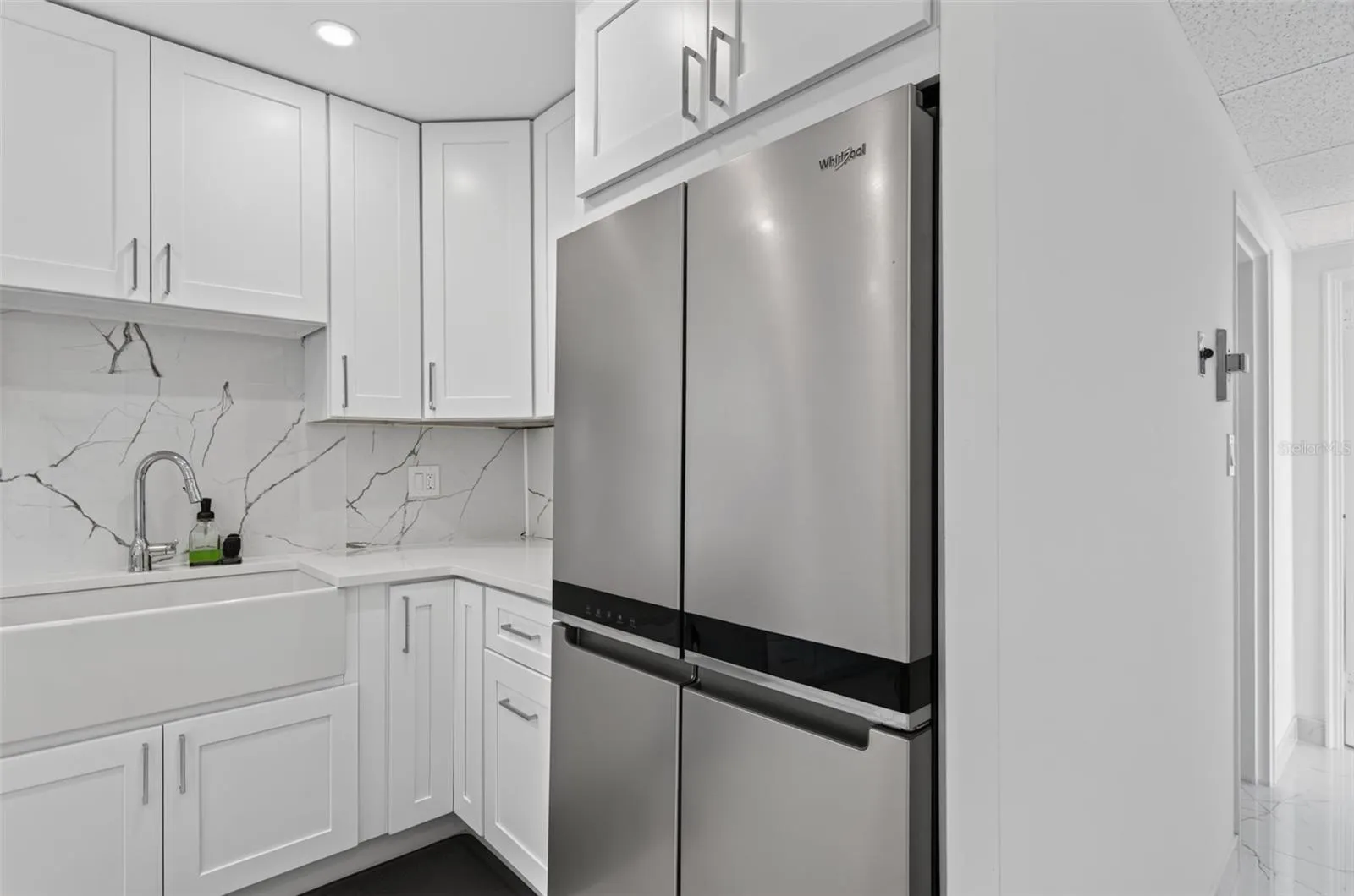 Large Refrigerator freezer and farmhouse sink add  beauty to this kitchen