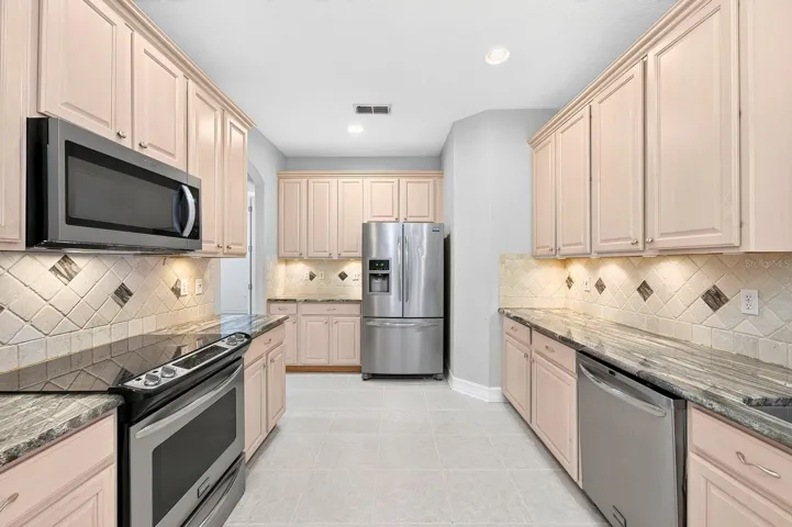 At the heart of the home, the spacious kitchen overlooks a casual dining area and inviting family room, creating the ideal gathering space for everyday living and entertaining.