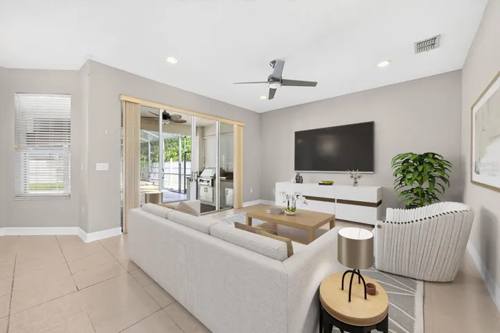 Generous family room has a wall of sliding glass doors that open to the lanai. Virtually Staged.