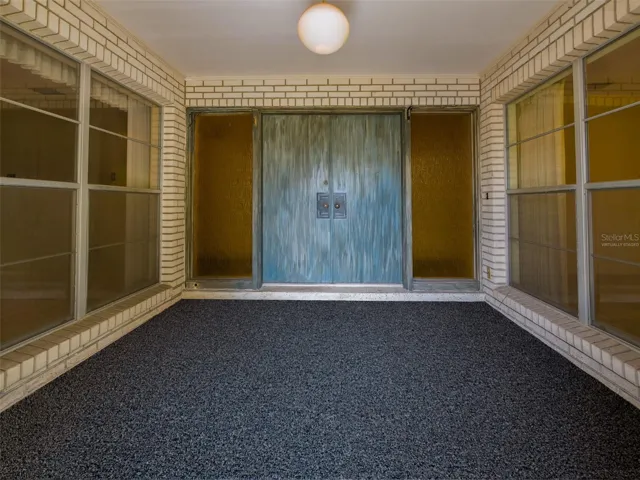 Virtually Staged Carpet - Enclosed entry porch with double doors