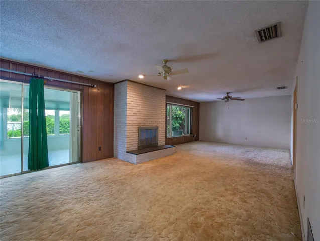 Living room with fireplace and sliding door to the sunroom