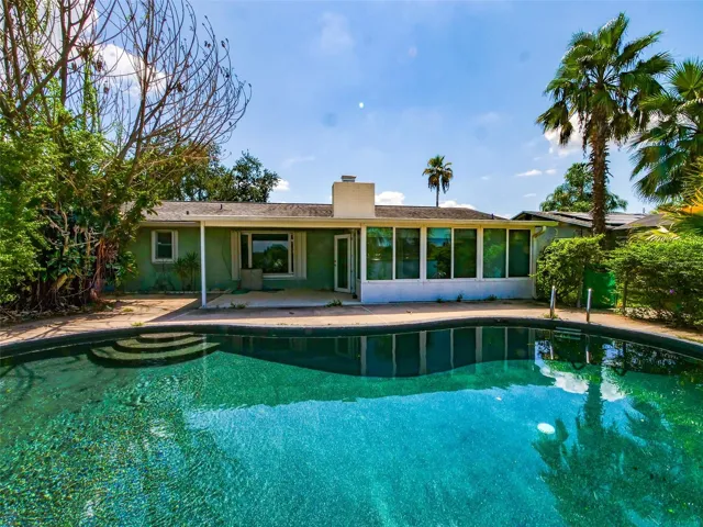 Back of home with pool and enclosed sunroom
