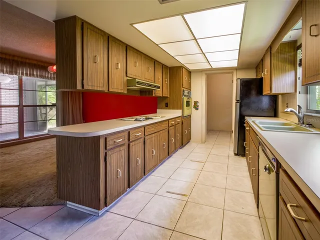 Galley kitchen with tile flooring and pass through to the dining room