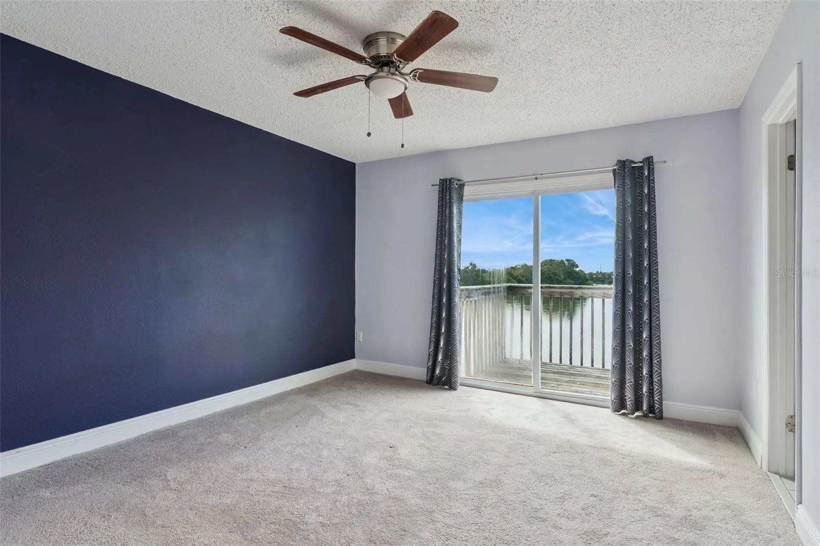 Primary Bedroom with view to the Balcony that overlooks the pond