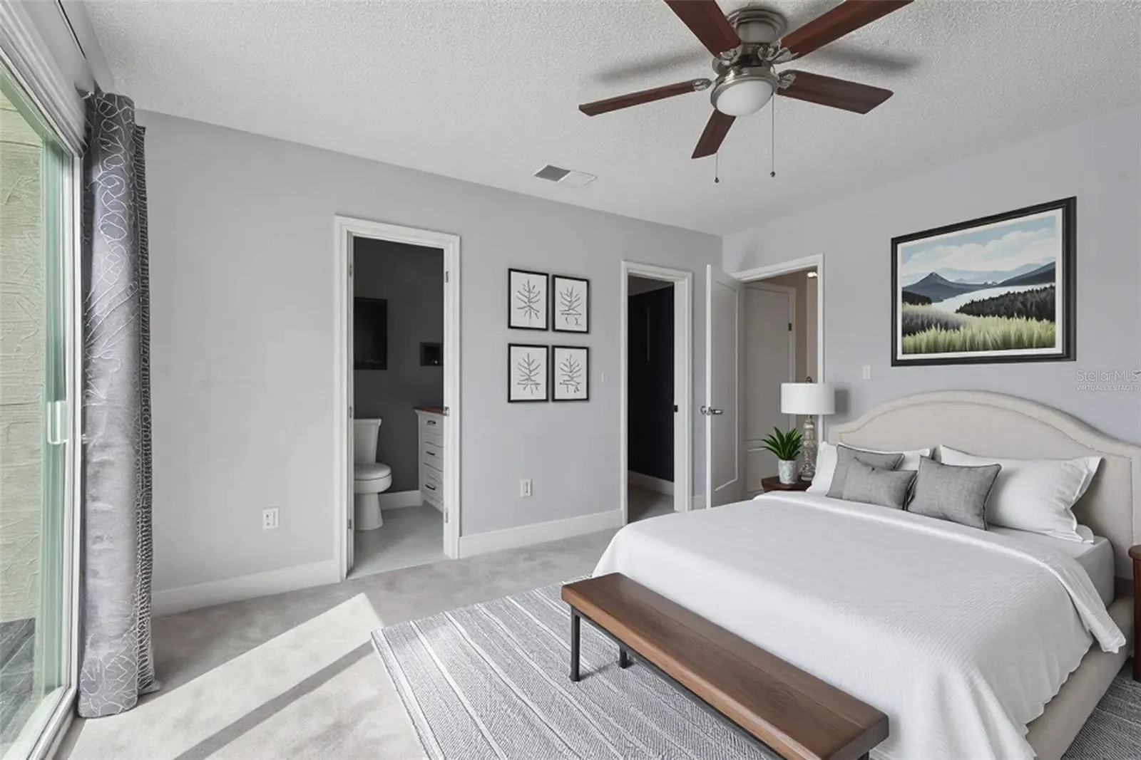 Virtually Staged Primary Bedroom with view to primary bathroom and walk-in Closet