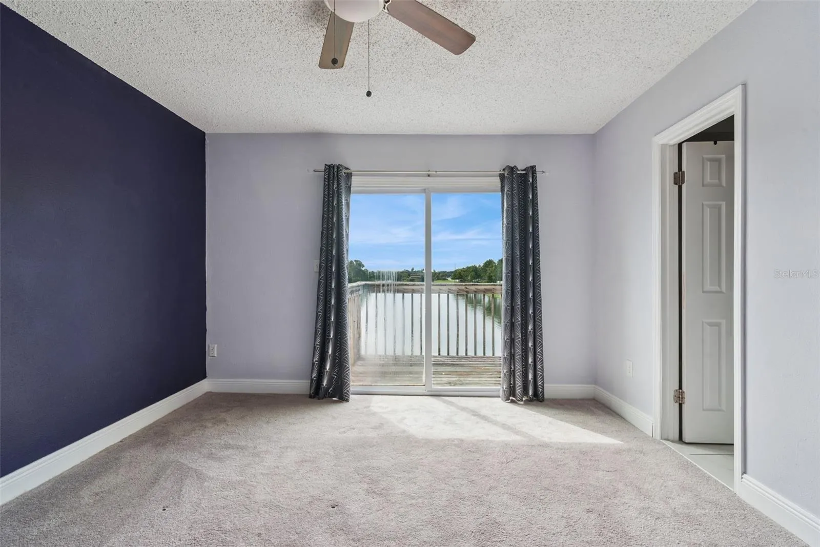 Primary Bedroom with view to the Balcony that overlooks the pond