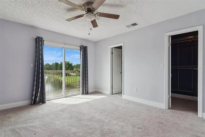 Primary Bedroom with view to the Balcony that overlooks the pond